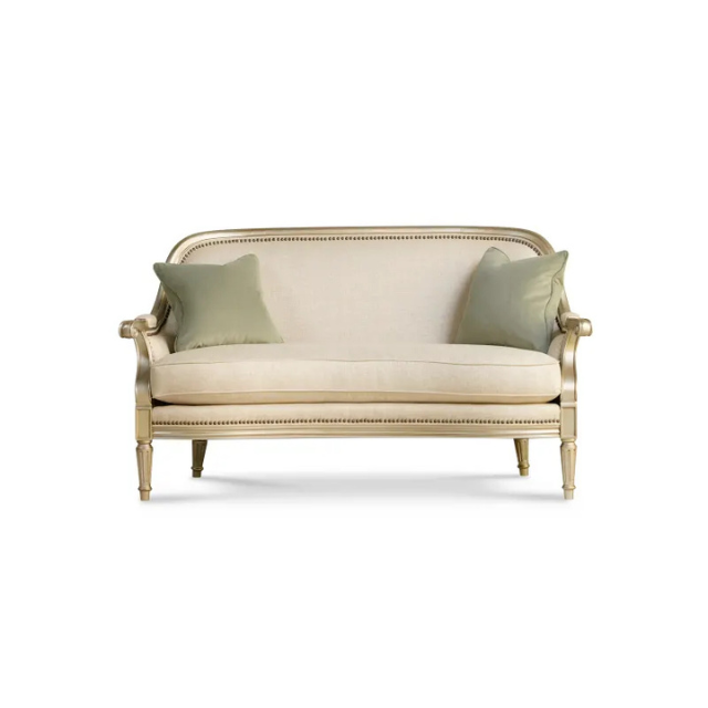 A white couch adorned with vibrant green pillows, creating a fresh and inviting living space.